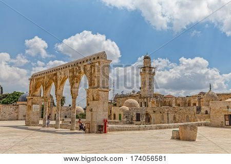 JERUSALEM, ISRAEL - MAY 23, 2016: Visitors view from the Dome of the Rock to the old stone arches at the top of the stairs and mosque minaret on the Temple Mount in the Old City.