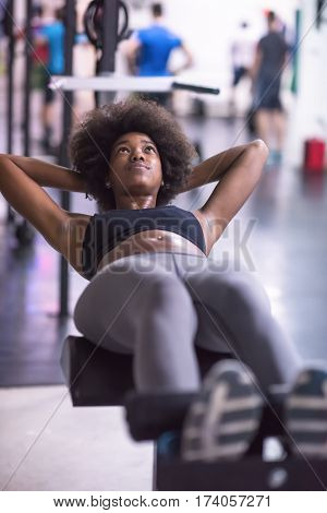young fit african american woman doing sit ups in fitness studio at the gym.Abdominal exercises Sit up