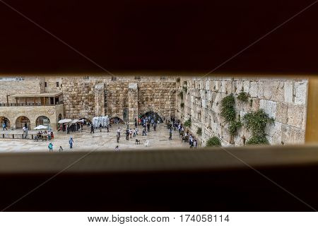 JERUSALEM, ISRAEL - MAY 23, 2016: View from the Mughrabi Bridge to the prayers making their wishes and prays at the Western Wall, located at the foot of the western side of the Temple Mount.