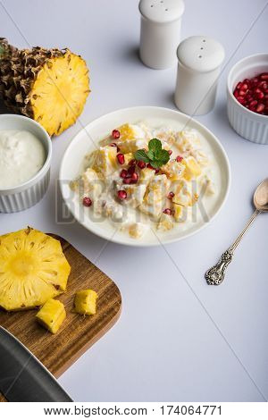 ananas or anaanaas or pineapple raita, chopped pieces of pineapple mixed with sweet curd and garnished with pomegranate and mint, favourite side dish or starter food in India