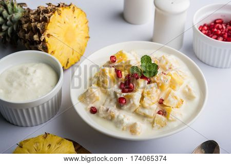 ananas or anaanaas or pineapple raita, chopped pieces of pineapple mixed with sweet curd and garnished with pomegranate and mint, favourite side dish or starter food in India