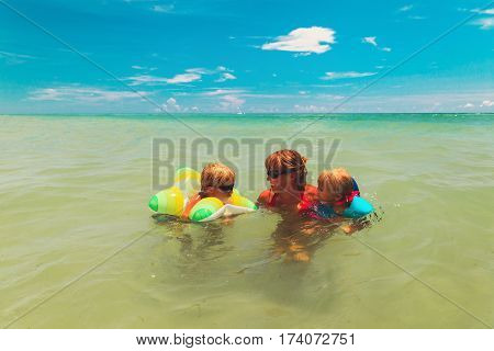 mother with little son and daughter swimming at sea