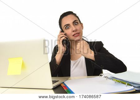 busy attractive woman in business suit working in stress desperate talking on mobile phone overwhelmed and overworked in office computer desk looking sad and depressed isolated on white