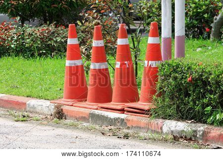Traffic cone row white and orange stripes set are roadside with copy space