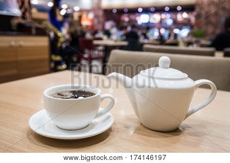 Teapot and cups are prepared for tea drinking in cafe