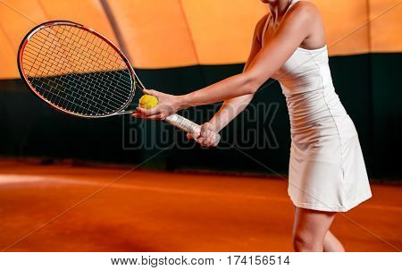 Sportswoman at the tennis court with racquet. Indoor tennis court
