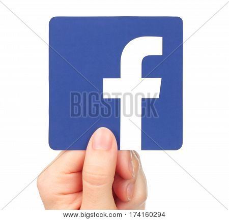 Kiev Ukraine - January 20 2016: Hand holds Facebook icon printed on paper. Facebook is a well-known social networking service