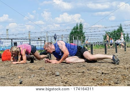 Tyumen Russia - July 9 2016: Steel Character extrim race on Voronino Hill. Army Test. People jumping crawlingpassing under a barbed wires or climbing obstacles during extreme obstacle race