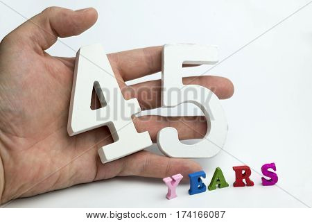 Hand holds a number forty-five on a white background.