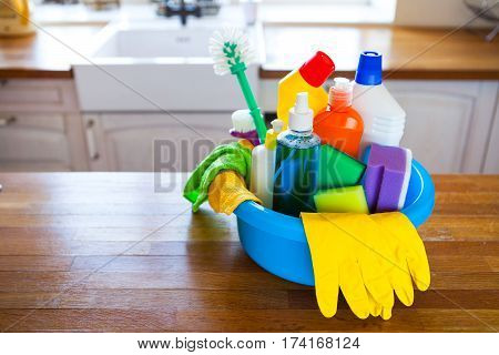 Basket With Cleaning Items On Blurry Background White Citchen. Cleaning Concept.