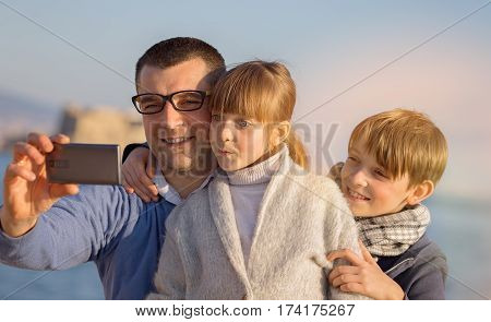Father with his children taking selfie outdoors