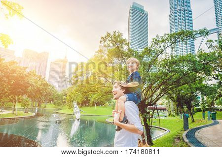 Father And Son Travelers In Malaysia Against A Background Towers Patronas Twins. Traveling With Chil