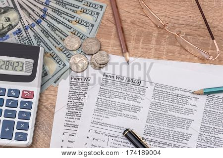 Tax Form W4  With Pen And Us Dollar, Calculator And Pen.