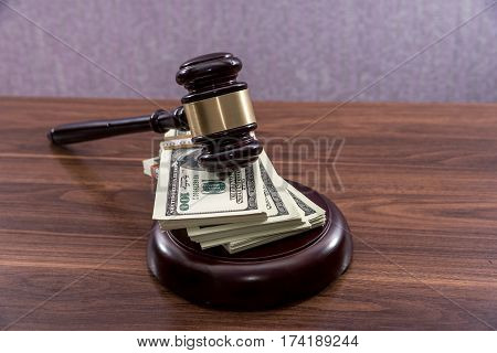 Judge Gavel With Dollars On Wooden Table