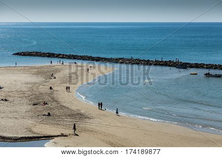 Beautiful top view of the beach with silhouettes of people and blue sea