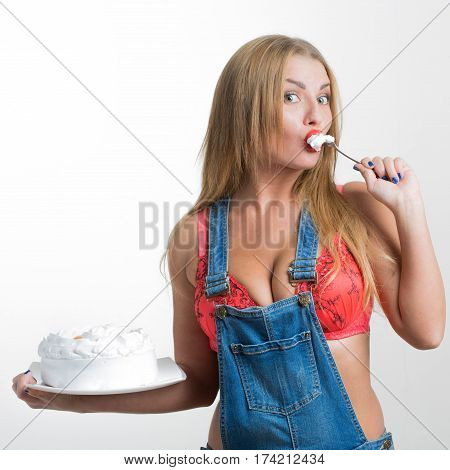 Busty sexy girl eating cake with whipped cream. white background
