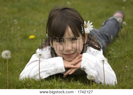 Junges Mädchen auf einem Löwenzahn