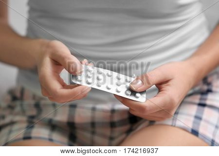 Close up view of young woman with pills. Gynecology concept
