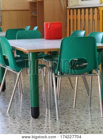 inside of a school classroom with green chairs and no children