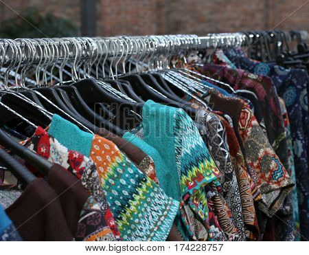 stall with many vintage clothes hanging in the flea market