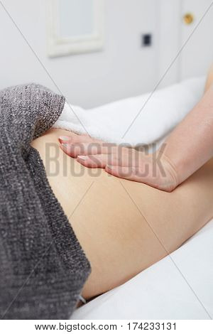 Deep tissue massage on a woman's hip gluteus muscles