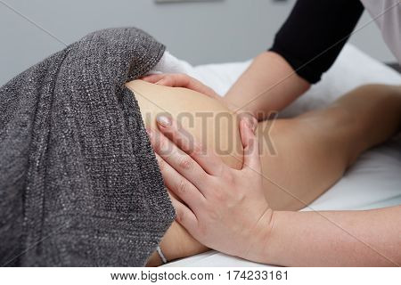 Deep tissue massage on a woman's hip gluteus muscles
