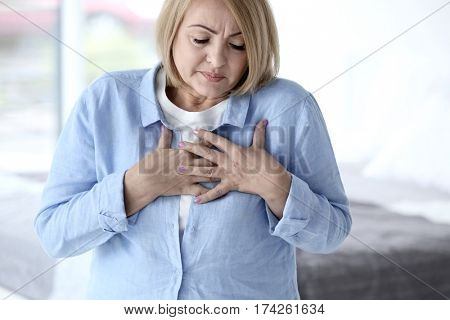 Senior woman having heart attack at home