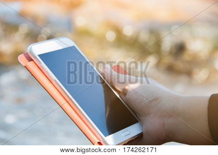 taking picture by smart phone selfie stick on blurred beautiful at beach background Vacation concept