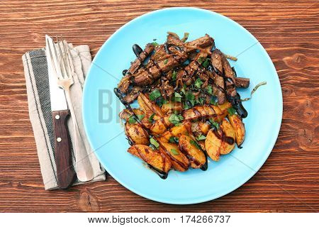 Homemade Slow Cooked Beef with Potatoes on wooden background