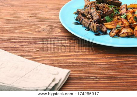 Homemade Slow Cooked Beef with Potatoes on wooden background