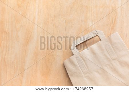 Clean brown kraft paper bag lying on a plywood table.