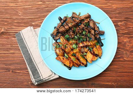 Homemade Slow Cooked Beef with Potatoes on wooden background