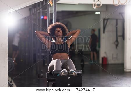 young fit african american woman doing sit ups in fitness studio at the gym.Abdominal exercises Sit up