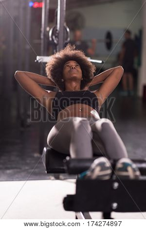 young fit african american woman doing sit ups in fitness studio at the gym.Abdominal exercises Sit up