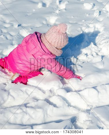 Little girl having fun playing in snow