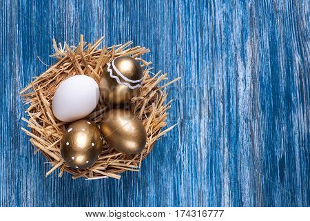 omposition with colorful Easter eggs on blue wooden table