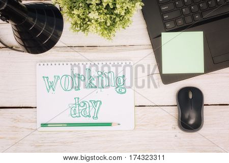 Workspace notebook and inscription in a scratchpad: working day
