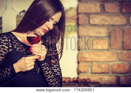Elegant beauty lady long hair full make up wearing black dress tasting wine in rural cottage interior celler