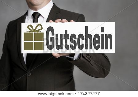 Gutschein (in German Gift Card) Is Held By A Businessman