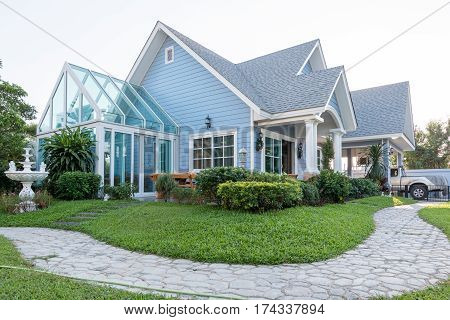 Bright Blue House In Sunlght With Colorful Poppies And Some Graceful Trees.