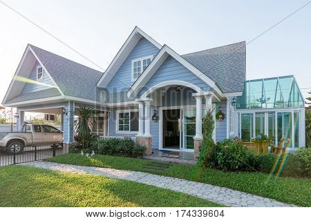 Bright Blue House In Sunlght With Colorful Poppies And Some Graceful Trees.