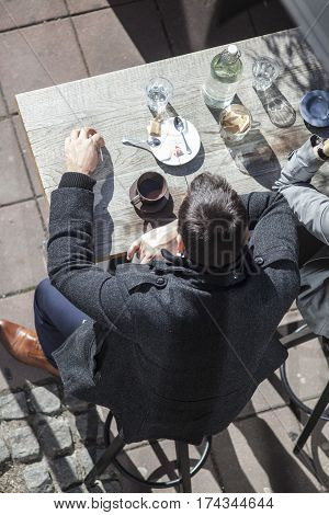Birdseye of well dressed people drinking coffee in a street bar