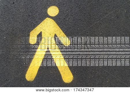 Painted sign on asphalt for pedestrian lane and tire track. Concept: road hazards for pedestrians