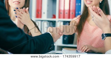 Close up of business handshake in the office. Serious business and partnership concept. Partners made deal sealed with handclasp.
