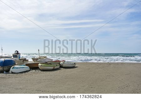 CABO DE GATA SPAIN - FEBRUARY 9 2016: Fishing boats at the shore of national park Cabo de Gata near Almeria (Andalusia Spain) and sea waves on the background.