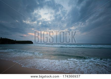 On the ocean during sunset with cloudy dramatic sky with strong waves