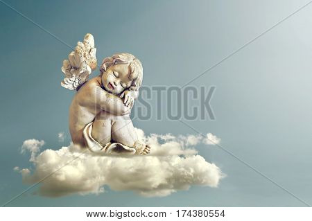 Little angel sitting and sleeping on the cloud