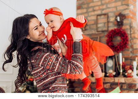 Beautiful moter and her little daughter  near Christmas tree