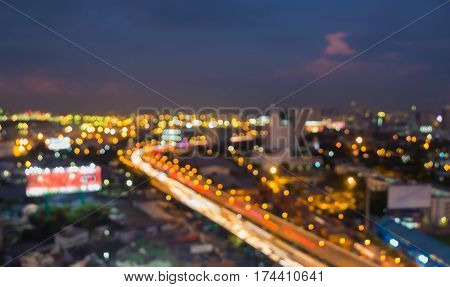 Night blur light city road intersection with downtown twilight skyline abstract background