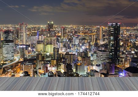 Opening wooden floor City downtown night lights Osaka cityscaepe background Japan